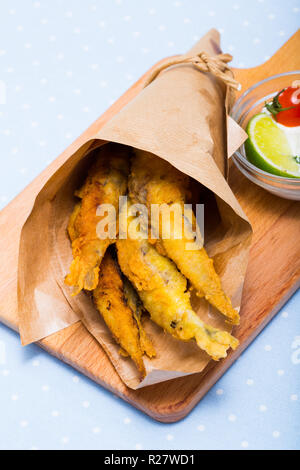 Tapas tradizionali spagnole - deep alici fritte servite con salsa di formaggio cremosa, calce e verdi Foto Stock