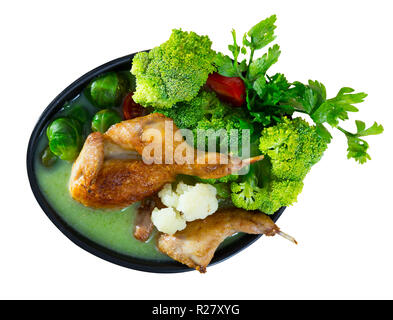 Minestra di crema bollite con quaglie, servita con broccoli, cavolini di Bruxelles e cavolfiori. Isolato su sfondo bianco Foto Stock