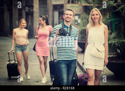 Ritratto di felice coppia turisti tenendo a piedi e trascinando valigie insieme Foto Stock