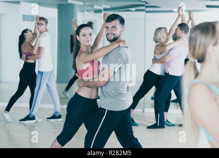 Gruppo di sorridenti adulti ballare la salsa nel club Foto Stock