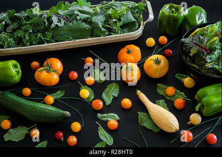 Cimelio di famiglia e pomodorini con erbe aromatiche fresche, kale e un assortimento di squash e peperoni. Foto Stock