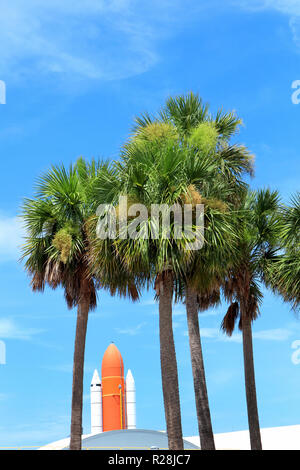 Il centro spaziale Kennedy entrata con un razzo spaziale e palme oltre il cielo blu in Florida, Stati Uniti d'America Foto Stock