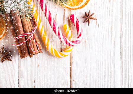 Sfondo di natale con la caramella canne e bastoncini di cannella. Foto Stock