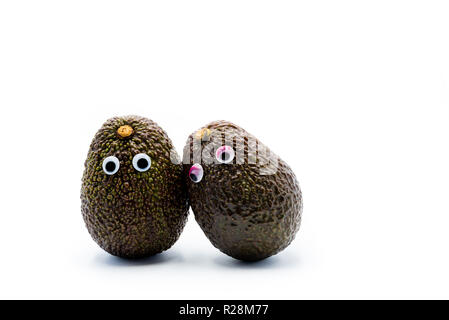 Romantico avocadi giovane con googly occhi come uomo e donna, funny food concept per progetti creativi. Foto Stock