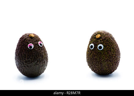 Romantico avocadi giovane con googly occhi come uomo e donna, funny food concept per progetti creativi. Foto Stock