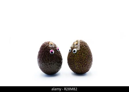 Romantico avocadi giovane con googly occhi come uomo e donna, funny food concept per progetti creativi. Foto Stock
