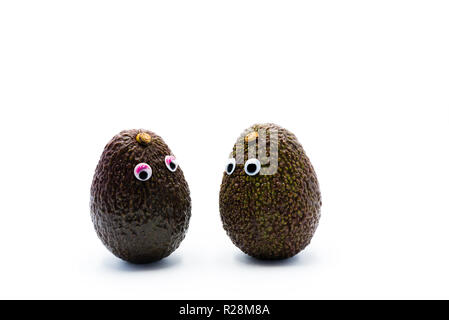 Romantico avocadi giovane con googly occhi come uomo e donna, funny food concept per progetti creativi. Foto Stock