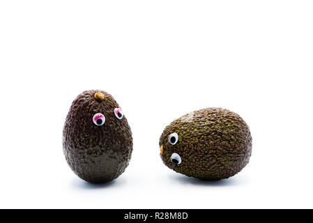 Romantico avocadi giovane con googly occhi come uomo e donna, funny food concept per progetti creativi. Foto Stock
