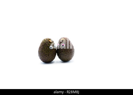 Romantico avocadi giovane con googly occhi come uomo e donna, funny food concept per progetti creativi. Foto Stock