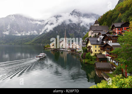 New Scenic 5 posti da cartolina vista del famoso Hallstatt Lakeside Town nelle Alpi austriache con nave passeggeri in bella la luce del mattino al sorgere del sole su una sun Foto Stock