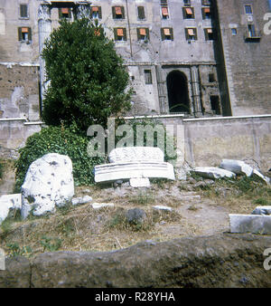 La forma arrotondata, pietre decorate in medio in primo piano è noto come la pietra miliare romano, o una traduzione esatta del latino Millarium Aureum sarebbe "Golden Milestone." fu commissionato dall'imperatore romano Augusto nel 20 A.C. e impostati nel Foro Romano, in quanto la sua posizione e ha segnato il punto in cui tutte le strade da/per met. In realtà si trattava di una colonna di bronzo dorato o forse rivestiti in marmo in bronzo dorato. Questa foto risale al 1970. Foto Stock