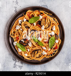 La pasta alla norma - cibo tradizionale italiano con melanzane, pomodoro, formaggio e basilico, vista dall'alto. Foto Stock