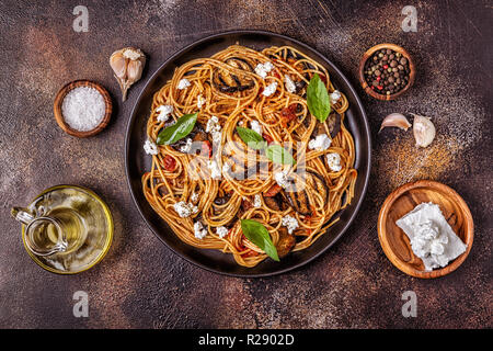 La pasta alla norma - cibo tradizionale italiano con melanzane, pomodoro, formaggio e basilico, vista dall'alto. Foto Stock