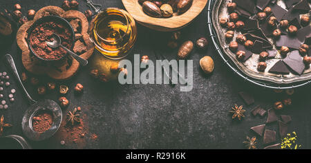 Sfondo di cioccolato con vari dadi, spezie, la polvere di cacao e liquori, vista dall'alto. Pasticceria fatti in casa con praline e tartufi ingredienti. Bro Foto Stock