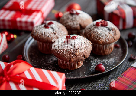 Cioccolatino natalizio deliziosi muffin servita su nero piastra in ceramica Foto Stock