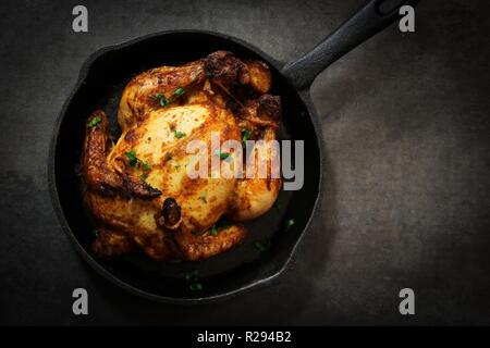 Herb masala torrefatto Cornish Hen / intero pollo mini ringraziamento Xmas pasto vista aerea su sfondo scuro Foto Stock