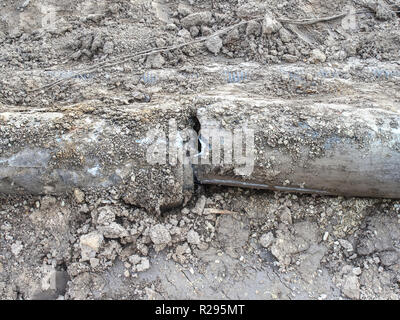 Vecchio tombino fognario contemplati nel suolo sulla costruzione di lato. Coperchio di fognatura su strada nella città. Foto Stock