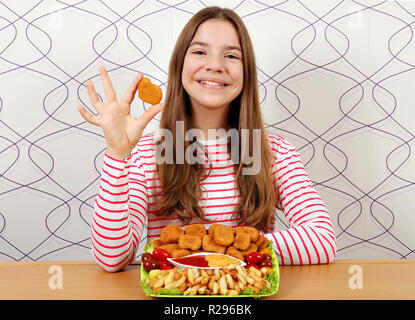 Felice ragazza adolescente con pepite di pollo e patatine fritte fast food Foto Stock