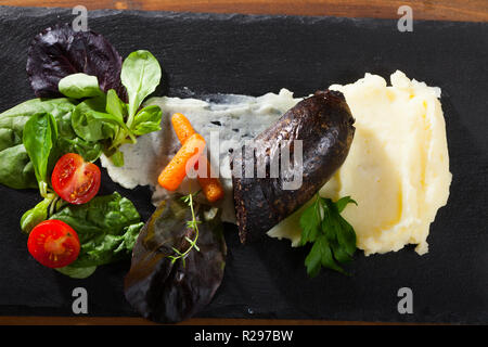 La morcilla servito su purea di patate e carote, Cherry Pomodoro ed insalata Foto Stock