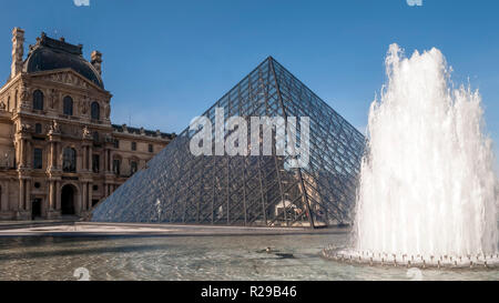 Bellissima vista della piramide del Louvre con fontana e getti d'acqua in azione, Parigi, Francia Foto Stock