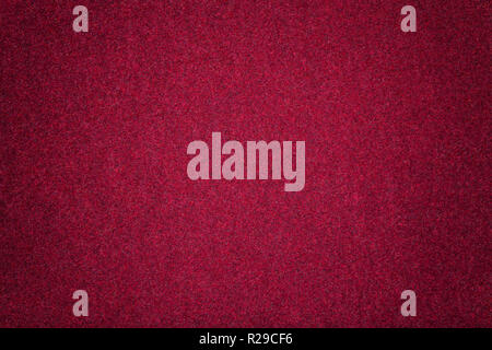 Rosso scuro dello sfondo opaco di tessuto scamosciato, primo piano. Texture di velluto di vino senza giunture di feltro di lana con vignette. Foto Stock