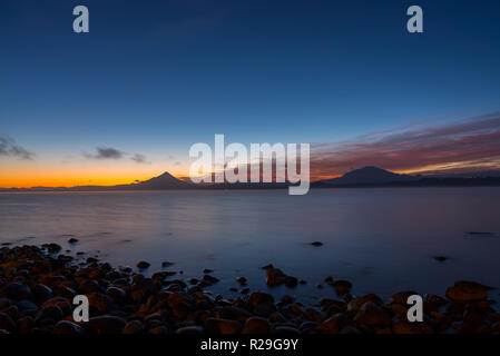 Paesaggio all'alba sul lago Llanquihue con del vulcano di Osorno e Calbuco in background, il Cile del sud Foto Stock