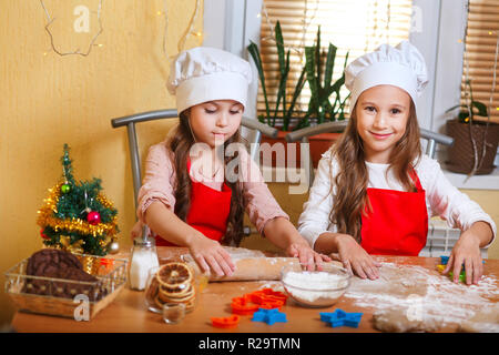 Due graziosi bambine la preparazione di biscotti di Natale in cucina a casa Foto Stock