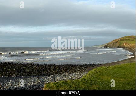 Spiaggia Llanrhystud in tarda serata luce guardando a nord lungo la costa a Aberystwyth oltre il surf e ghiaiosa spiaggia costiera Foto Stock