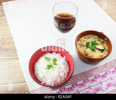 Moqueca di pesce e peperoni, cibo brasiliano, servito con riso bianco su un tavolo di legno. Foto Stock