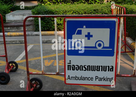 Primo piano del parcheggio ambulanza accedi sia tailandese ed inglese di fronte ad un edificio Foto Stock