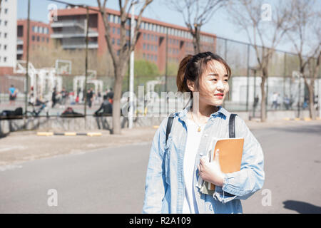 Ritratto di giovane donna asiatica con libri Foto Stock