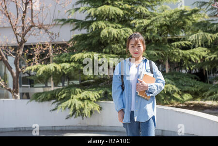 Ritratto di giovane donna asiatica con libri Foto Stock