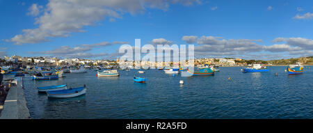 Il villaggio di Marsaxlokk porta sull'isola mediterranea di Malta con le tradizionali imbarcazioni locali. Foto Stock