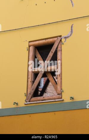 Finestra rinforzata con elementi in legno in un edificio in rovina a causa di terremoto (Tolentino Marche, Italia) Foto Stock