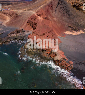Vista aerea di onde che si infrangono su una formazione di roccia. Playa El Golfo. Spiaggia nera di Charco de los Clicos. Lanzarote isole Canarie Spagna Foto Stock