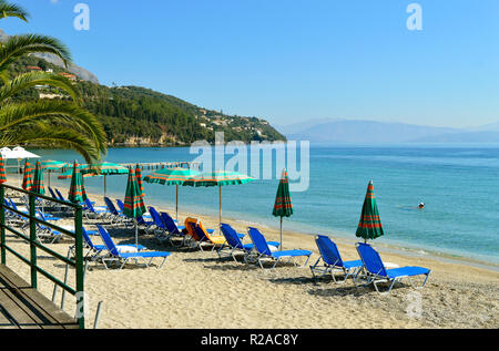 Sedie a sdraio sulla spiaggia di Ipsos a Corfu un'isola greca nel Mar Ionio Foto Stock