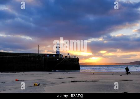 St Ives, Cornwall, Regno Unito. Xviii Nov, 2018. Meteo. Vi è stata una fantastica sunrise attraverso St Ives Harbour in Cornovaglia con venti forti su un lieve novembre mattina. Il tempo è impostato in modo da diventare più fresco nella settimana di anticipo. Credito: Paolo Melling/Alamy Live News Foto Stock