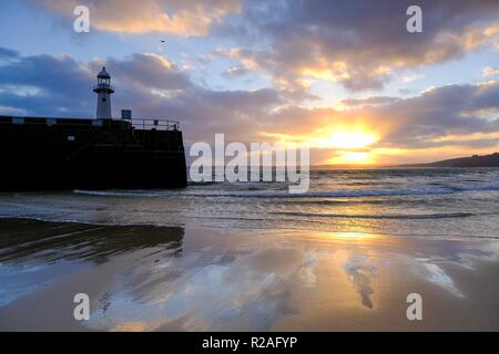 St Ives, Cornwall, Regno Unito. Xviii Nov, 2018. Meteo. Vi è stata una fantastica sunrise attraverso St Ives Harbour in Cornovaglia con venti forti su un lieve novembre mattina. Il tempo è impostato in modo da diventare più fresco nella settimana di anticipo. Credito: Paolo Melling/Alamy Live News Foto Stock