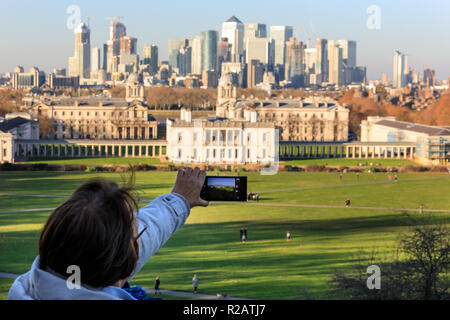 Il parco di Greenwich, Londra, Regno Unito, 18 Nov 2018. La gente di stand e guardare il tramonto dal generale Wolfe statua, con viste panoramiche dalla cima della collina verso Canary Wharf. Foto Stock