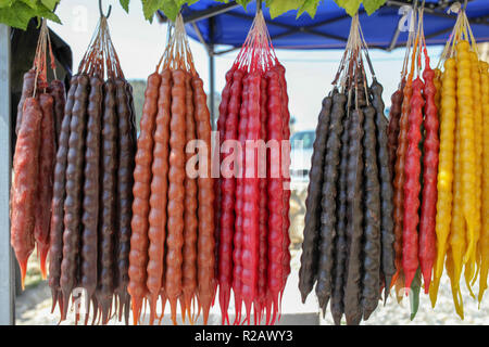 Churchkhela. In stile Georgiano tradizionale di dolci fatti in casa con nocciole, noci, succo d'uva, miele, farina di grano tenero. Il dessert venduti nel locale mercato alimentare di Georg Foto Stock