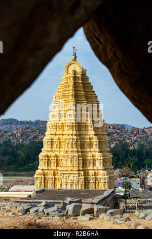 Tempio Virupaksha incorniciata da due enormi rocce. Vista dalla collina Hemakuta al tramonto in Hampi.Karnataka, India Foto Stock