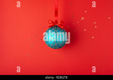 Emerald palla di Natale con ornamenti d'oro appeso sul nastro rosso. In stile minimale holiday card. Foto Stock