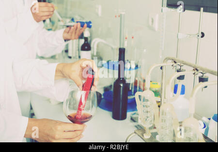 Vista sul vino che è controllato sul componente saturazione in laboratorio sulla fabbrica di cantina Foto Stock
