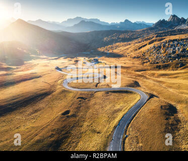 Strada tortuosa in valle di montagna al tramonto in autunno. Vista aerea di strada asfaltata in Passo Giau. Dolomiti, Italia. Vista superiore della carreggiata, montagne, Mead Foto Stock