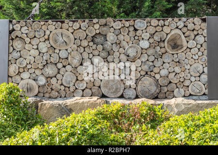 Tagliare tronco di albero e il ramo muro costituito da registri orizzontali Creazione di un aspetto di un certo numero di differenti dimensioni cerchi congiunti insieme per creare questo barrie Foto Stock