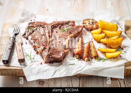 Fresh tbone steak condito con sale e rosmarino Foto Stock