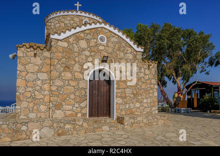 Paralimini, Cipro - 25 Giugno 2018: la splendida vista della chiesa di profitto Elias in Parlimini Cipro. Albero di grandi dimensioni con nastri di preghiere legate al Foto Stock