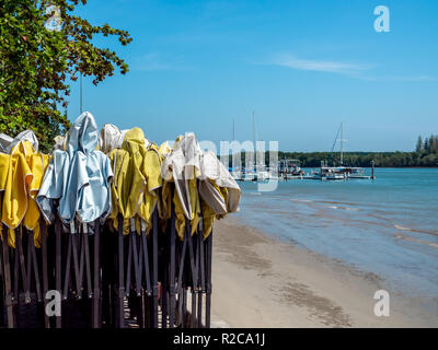 Il vecchio bianco e giallo outdoor tenda di piegatura permanente sulla spiaggia sporca sfondo con yacht porto sulla giornata di sole con una copia spazio. Foto Stock