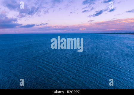 Bella viola tramonto oltre oceano tranquillo litorale - vista aerea Foto Stock