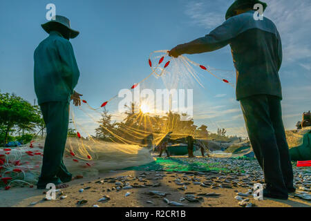 I pescatori stanno facendo la rete di pesca dopo la cattura come un modo di vivere nel villaggio costiero di pesca. Questo è duro lavoro, ma molte famiglie a Phan Thiet, Foto Stock